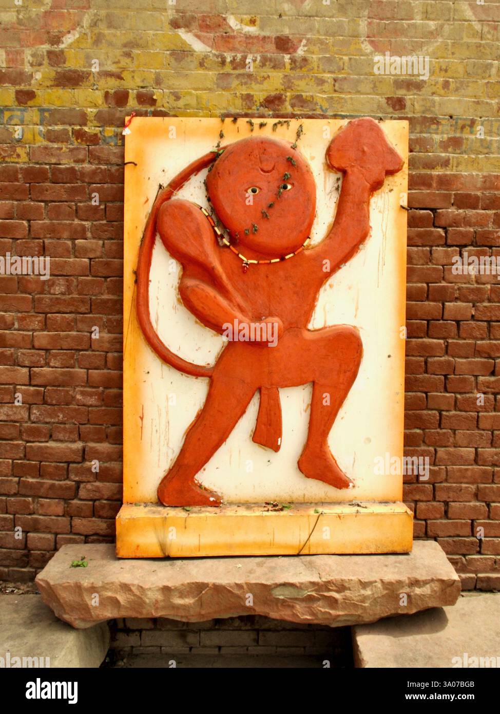 Relief von Hanuman in Varanasi, Indien, zeigt die Gottheit, die einen Berg hält, und symbolisiert Hingabe, Stärke und Schutz im Hinduismus. Stockfoto