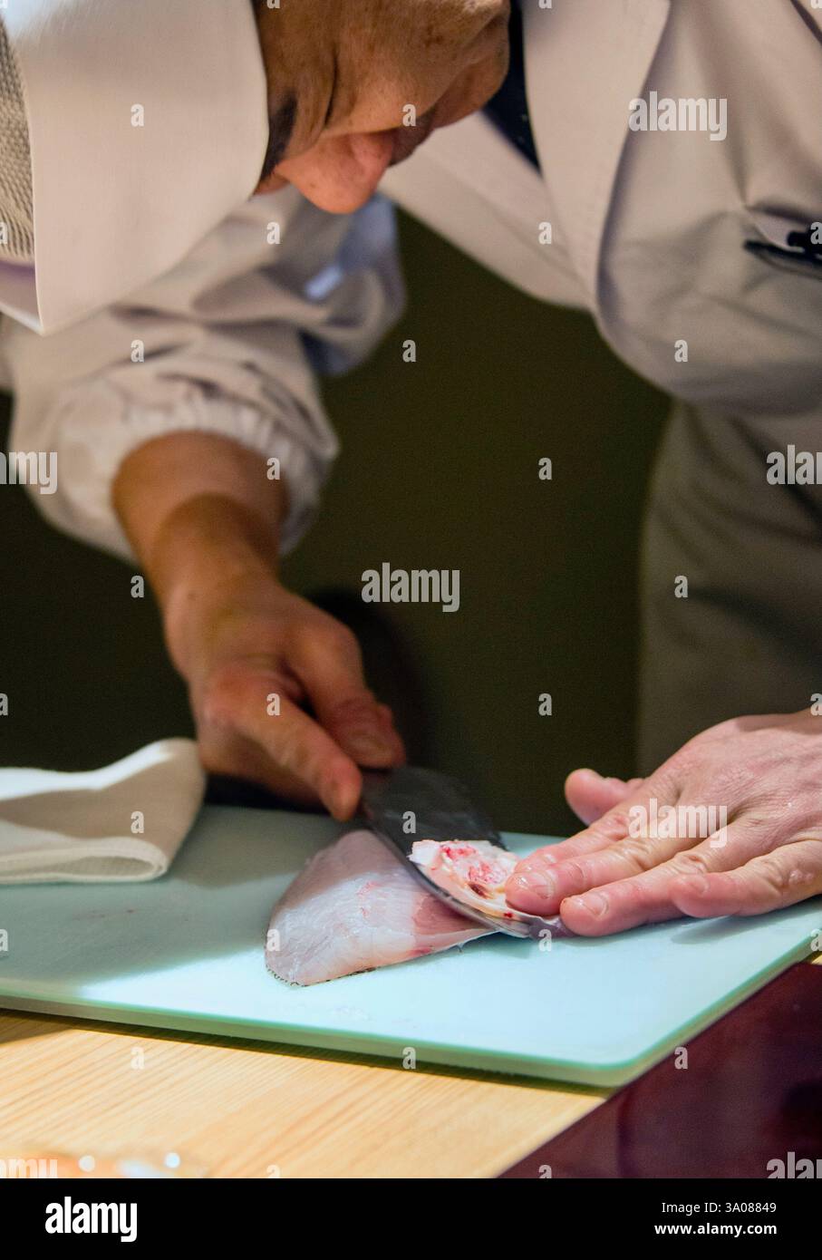 Der Küchenchef Hiroyuki Ogino schneidet im Restaurant Hassan im Bezirk Roppongi in Tokio, Japan, dünne Sashimi-Scheiben. ROB GILHOOLY FOTO Stockfoto
