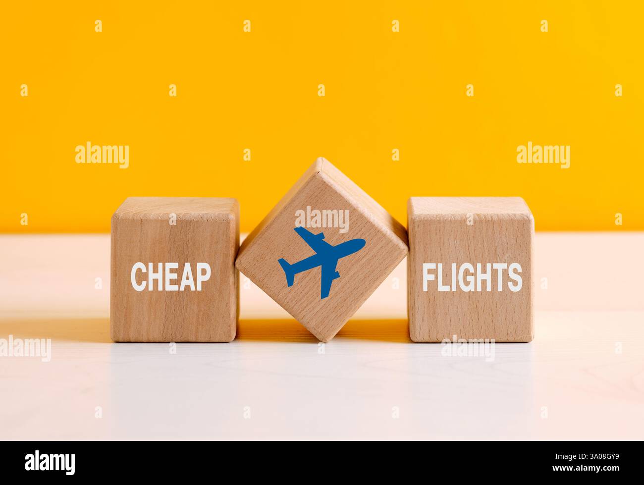 Ankündigung billiger Flüge mit Flugzeugsymbol auf Holzwürfeln, die erschwingliche Flugoptionen darstellen Stockfoto