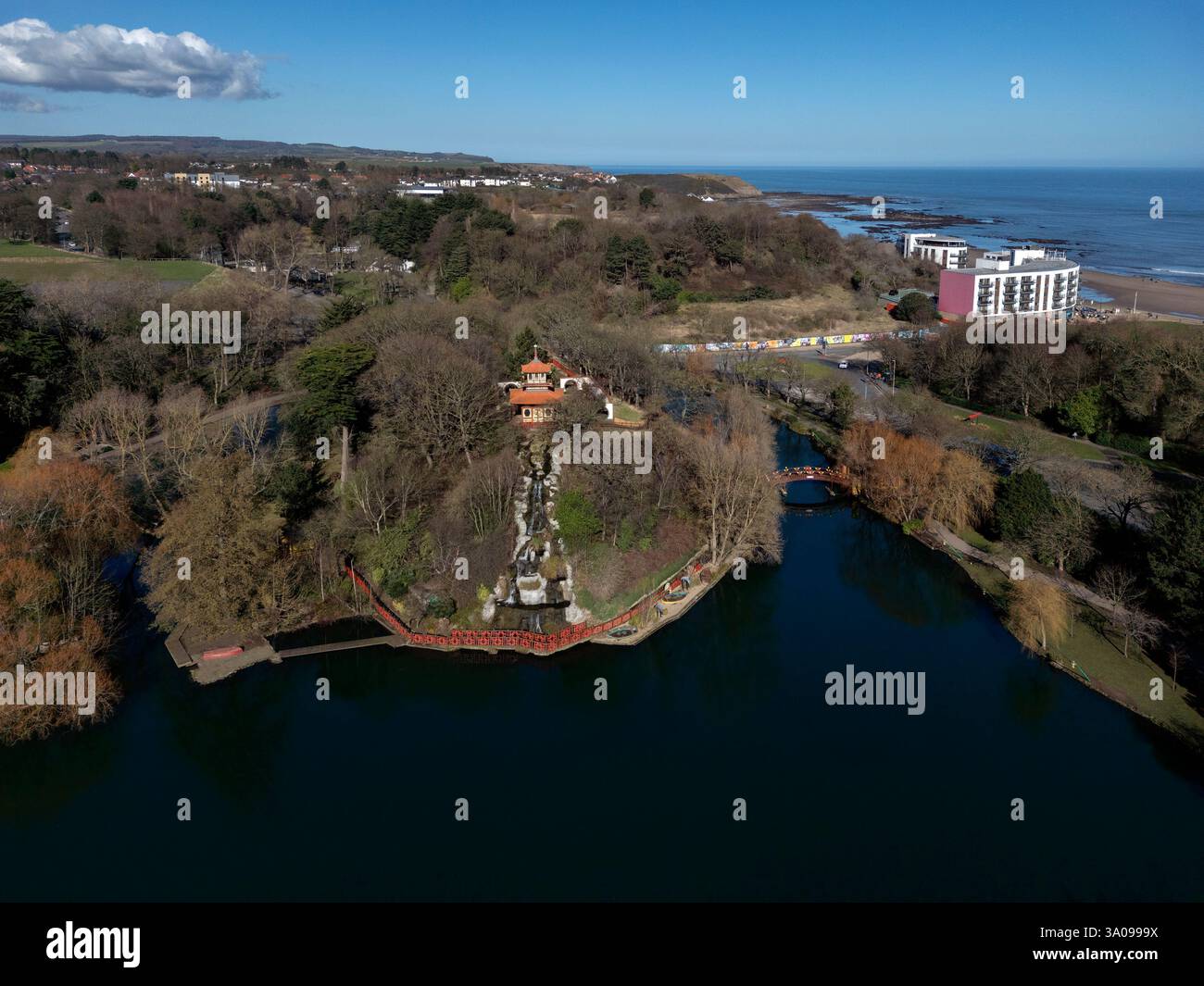 Blick aus der Vogelperspektive auf die Pagode, den See und den Wasserfall im Peasholm Park, einem orientalischen Stadtpark in der Küstenstadt Scarborough im Norden Stockfoto Blick aus der Vogelperspektive auf die Pagode, den See und den Wasserfall im Peasholm Park, einem orientalischen Stadtpark in der Küstenstadt Scarborough im Norden Stockfoto