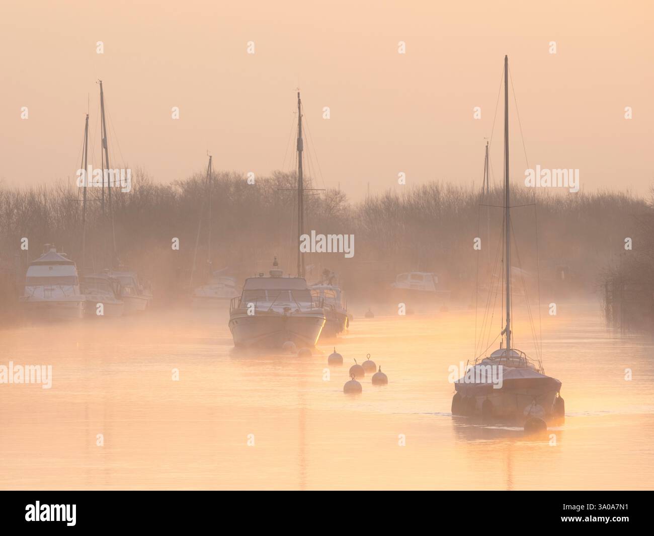 River Frome, Wareham, Dorset, Großbritannien. März 2023. Wetter in Großbritannien: Boote, die am Frome ankern, sind bei Sonnenaufgang zu Beginn eines weiteren schönen Frühlingstages in weichem Nebel gehüllt. Das herrliche Frühlingswetter wird sich bis weit in die Woche fortsetzen. Quelle: Celia McMahon/Alamy Live News Stockfoto