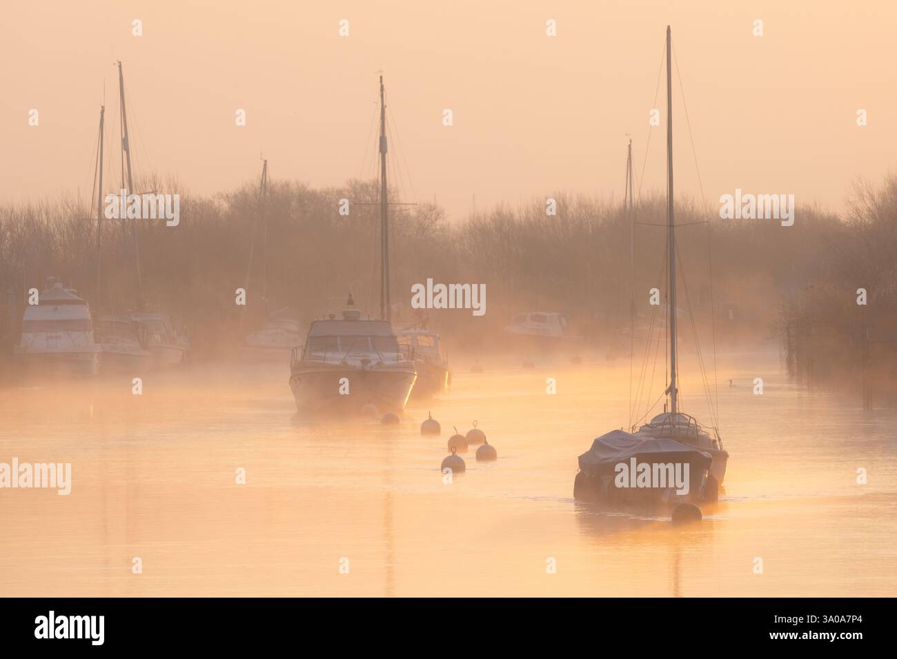 River Frome, Wareham, Dorset, Großbritannien. März 2023. Wetter in Großbritannien: Boote, die am Frome ankern, sind bei Sonnenaufgang zu Beginn eines weiteren schönen Frühlingstages in weichem Nebel gehüllt. Das herrliche Frühlingswetter wird sich bis weit in die Woche fortsetzen. Quelle: Celia McMahon/Alamy Live News Stockfoto