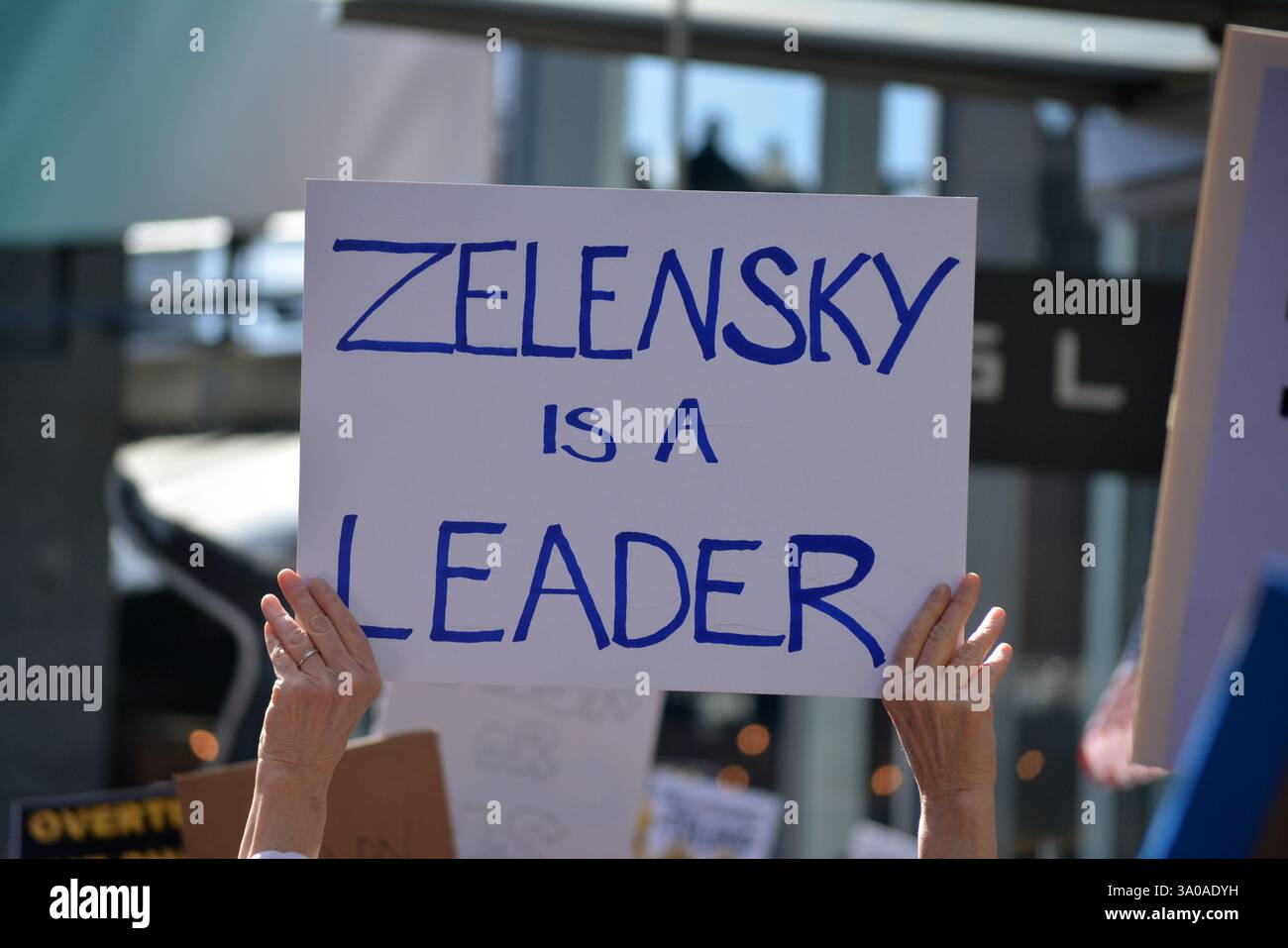 Zeichen der Unterstützung für die Ukraine bei einem Protest gegen Elon Musk und DOGE Kürzungen der Regierungsausgaben vor einem Tesla-Händler in New York City. Stockfoto
