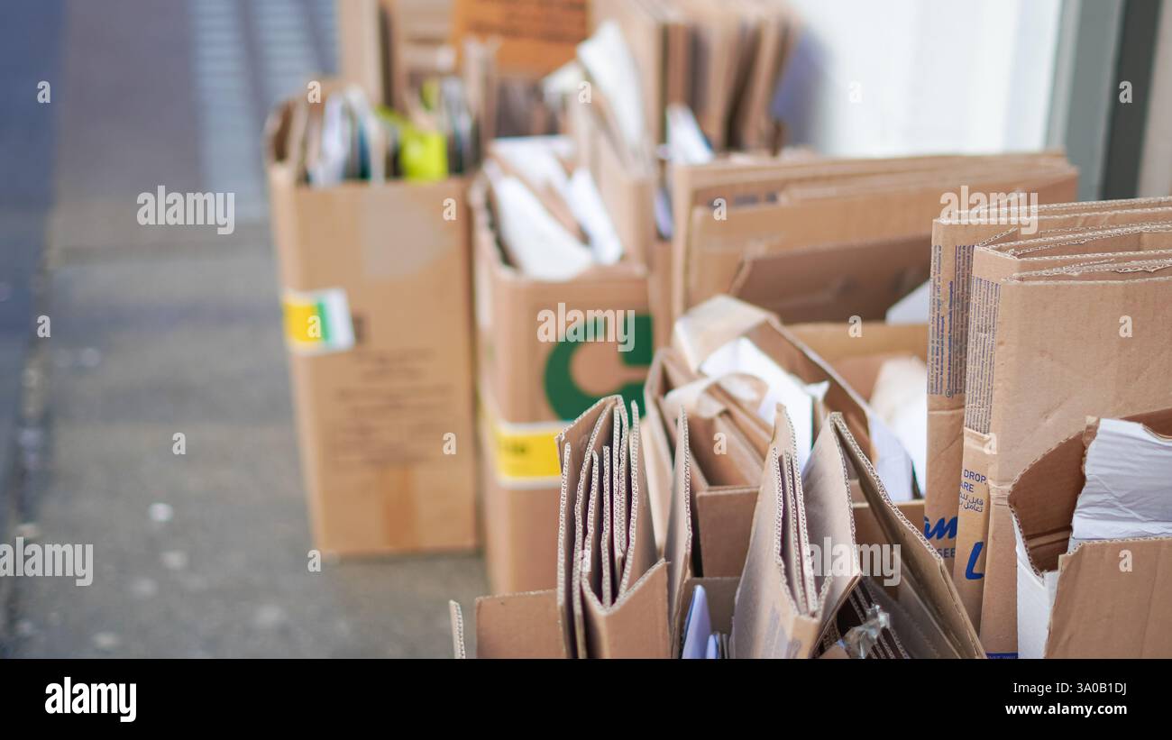 Recycelte Kartonstapel, die für die Abfallentsorgung im Freien ordentlich gestapelt werden. Stockfoto