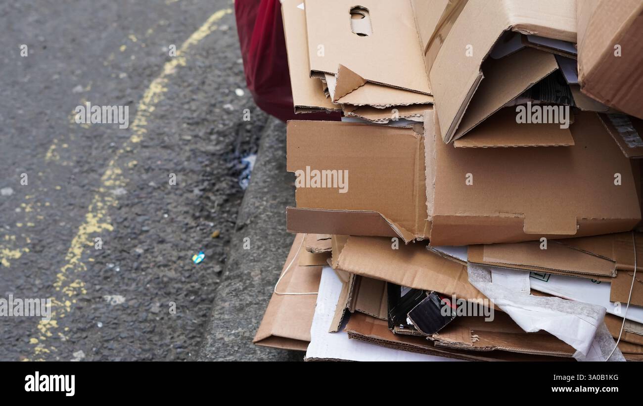 Gestapelte Pappschachteln im Freien, organisiert für eine ordnungsgemäße Abfallentsorgung. Stockfoto