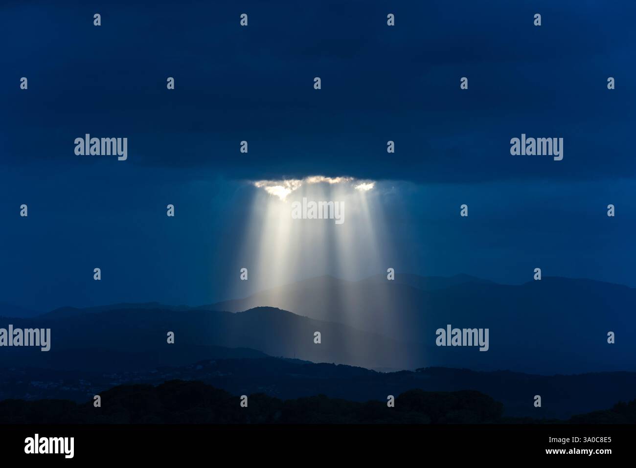 SONNENSTRAHLEN DURCH DUNKLE STURMWOLKEN ÜBER DEN KÜSTENBERGEN PALAFOLLS MARESME BARCELONA PROVINZ KATALONIEN SPANIEN Stockfoto