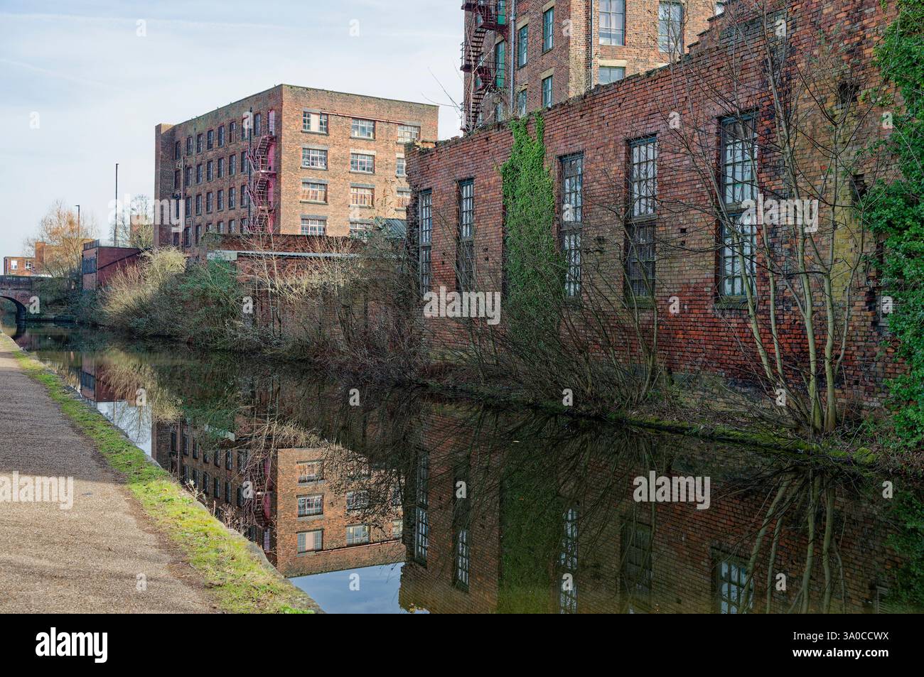 Historische Backsteinmühle spiegeln sich an klaren Tagen in einem ruhigen Kanal wider. Stockfoto