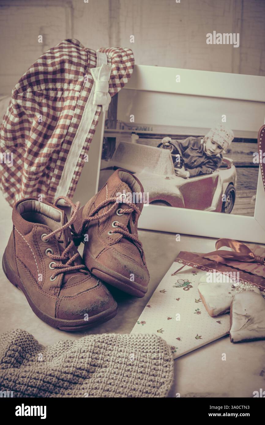 Das erste Paar Schuhe, Foto, Hut und andere Erinnerungen an Kindheit und Kindheit, Vintage-Stil, Kopierraum Stockfoto