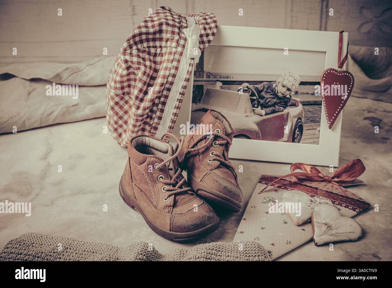 Das erste Paar Schuhe, Foto, Hut und andere Erinnerungen an Momente der Kindheit und Kindheit, Vintage-Stil, vertikal Stockfoto
