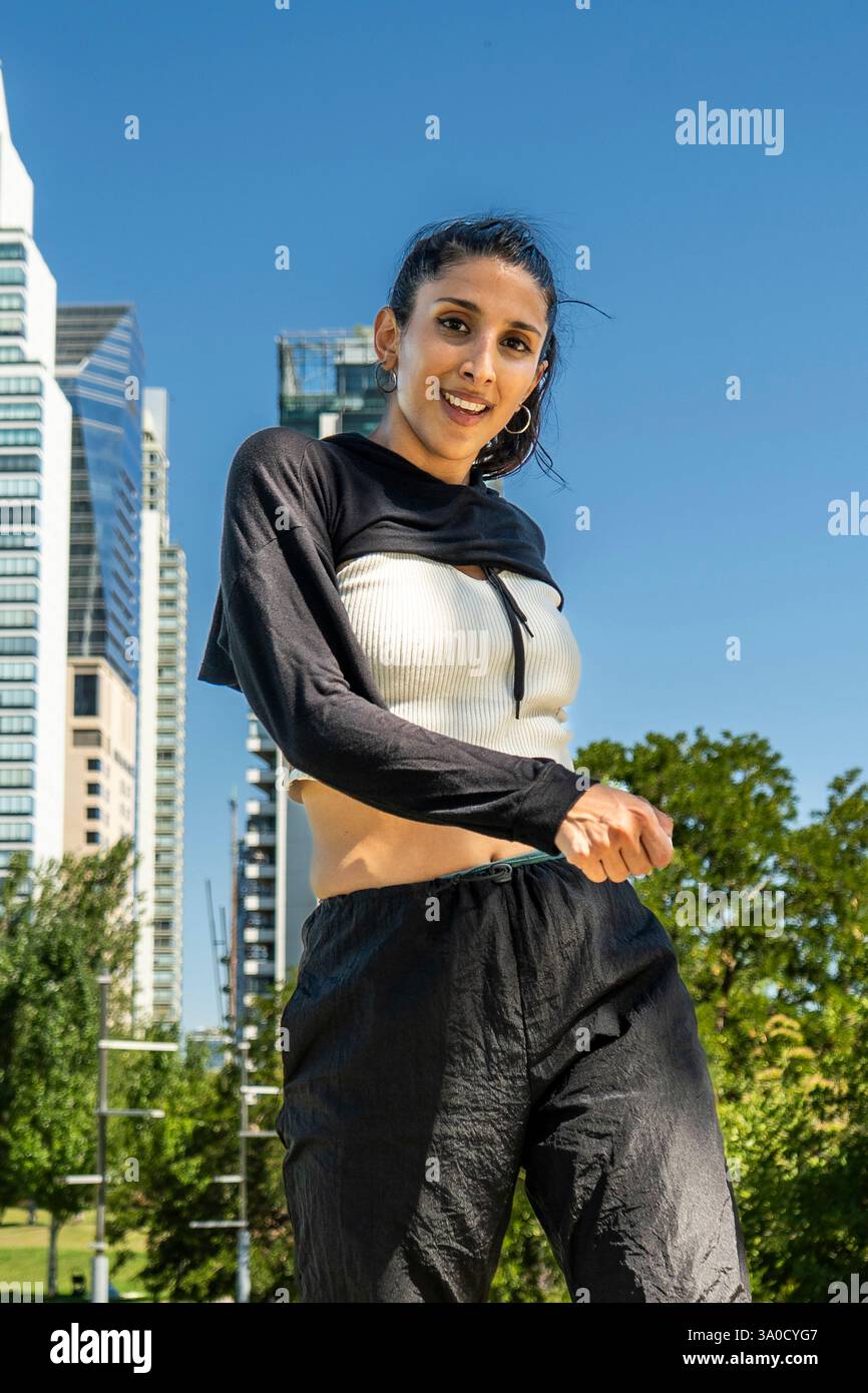 Anmutige Tänzerin, die ihre Fähigkeiten vor einer modernen Skyline demonstriert Stockfoto