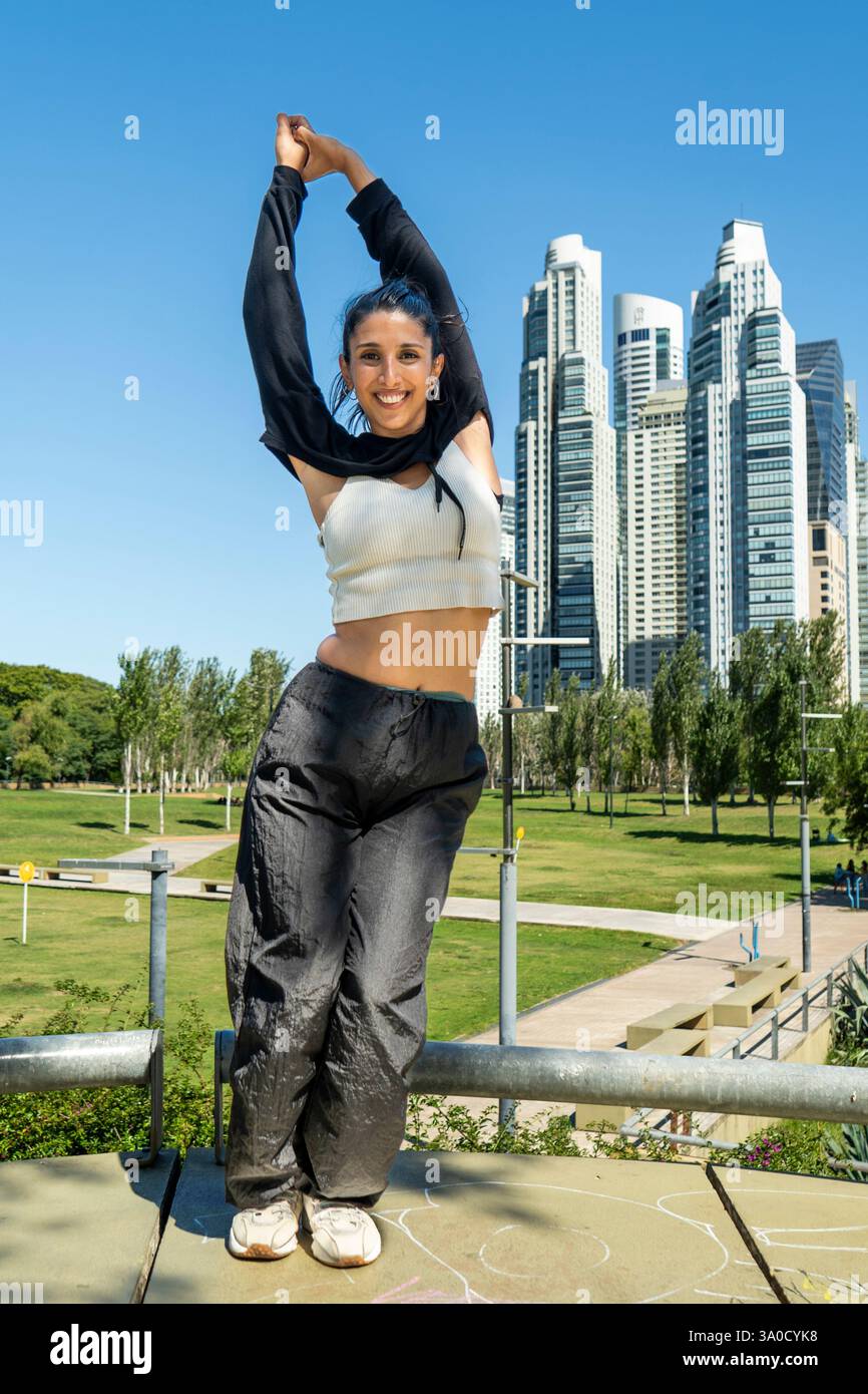 Dynamische Tänzerin bringt Energie in eine grüne Stadt Stockfoto