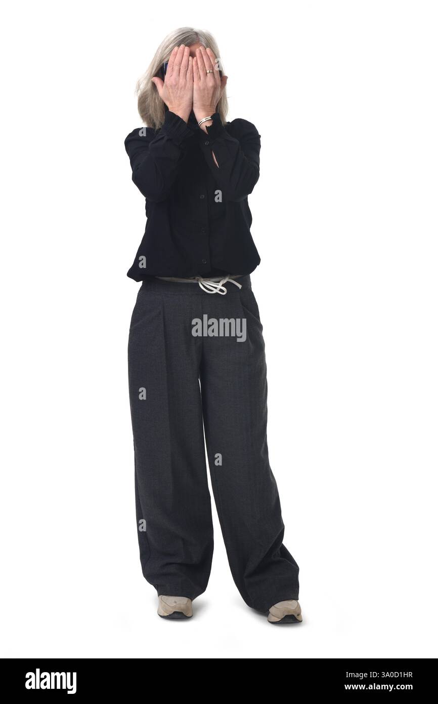 Vorderansicht einer Frau, die ihr Gesicht mit ihren Händen auf weißem Hintergrund bedeckt Stockfoto