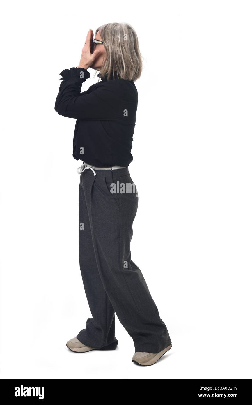 Seitenansicht einer Frau, die ihr Gesicht mit ihren Händen auf weißem Hintergrund bedeckt Stockfoto