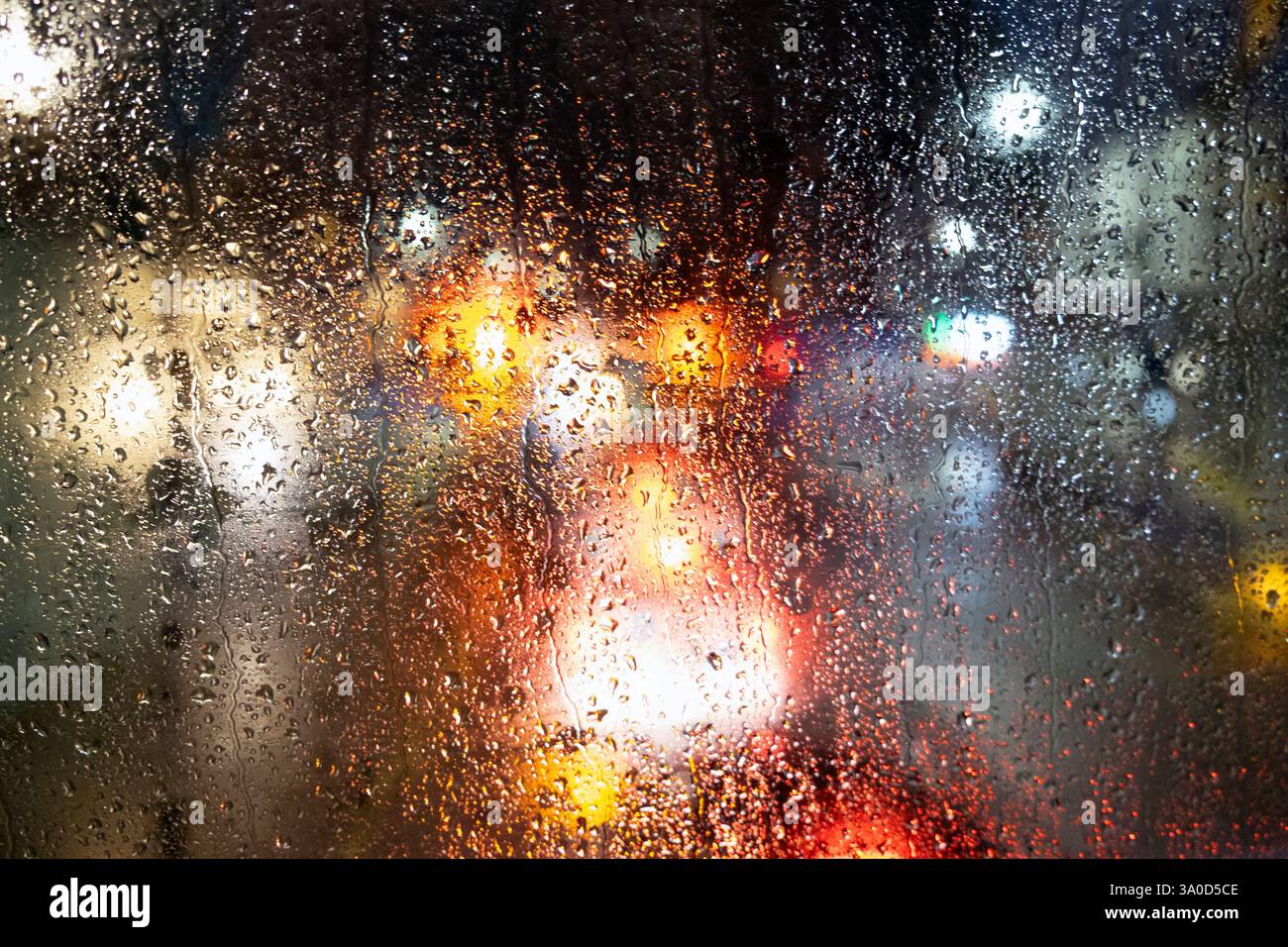 Blick auf farbenfrohe Geschäfte und Verkehrsampeln auf einer Straße bei Nacht in London Blick durch einen Doppeldeckerbus im obersten Stockwerk regnerisches Fenster London UK Stockfoto