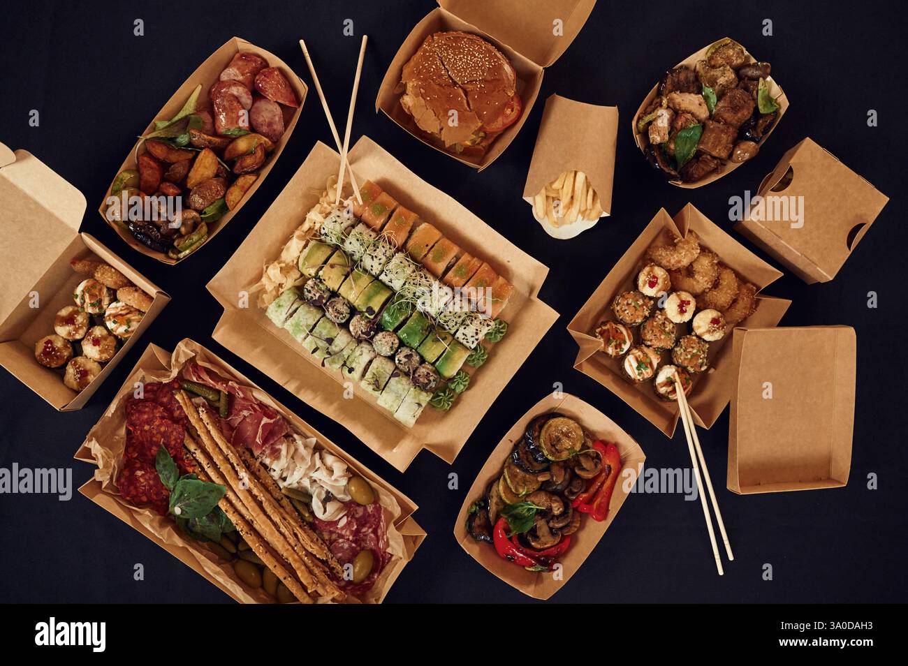 Blick von oben auf den Tisch mit Essen darauf. Fleisch, Gemüse, Sushi, Pommes frites, Burger, Pilze. Stockfoto