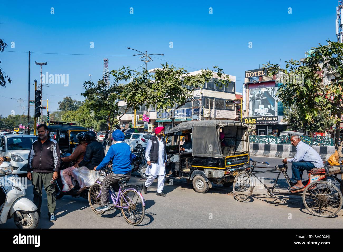 Eine belebte Straße mit Fußgängern und Verkehr aller Art in einer indischen Stadt. Bathinda, Punjab, Indien. Stockfoto