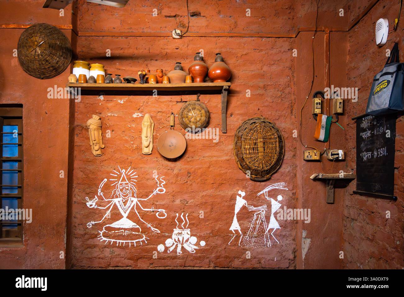 Gemälde des täglichen Lebens der Einheimischen an der Wand einer Küche. Maharashtra, Indien. Stockfoto
