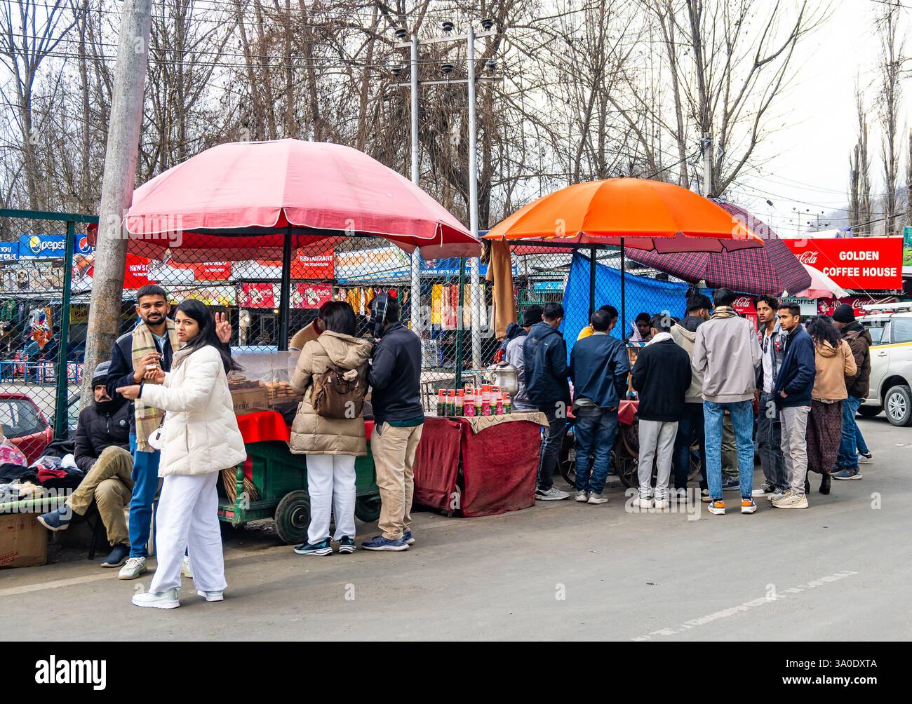 Einheimische, die an der Straße vorbeifahren, bieten Snacks und Süßigkeiten. Srinagar, Jammu und Kaschmir, Indien. Stockfoto