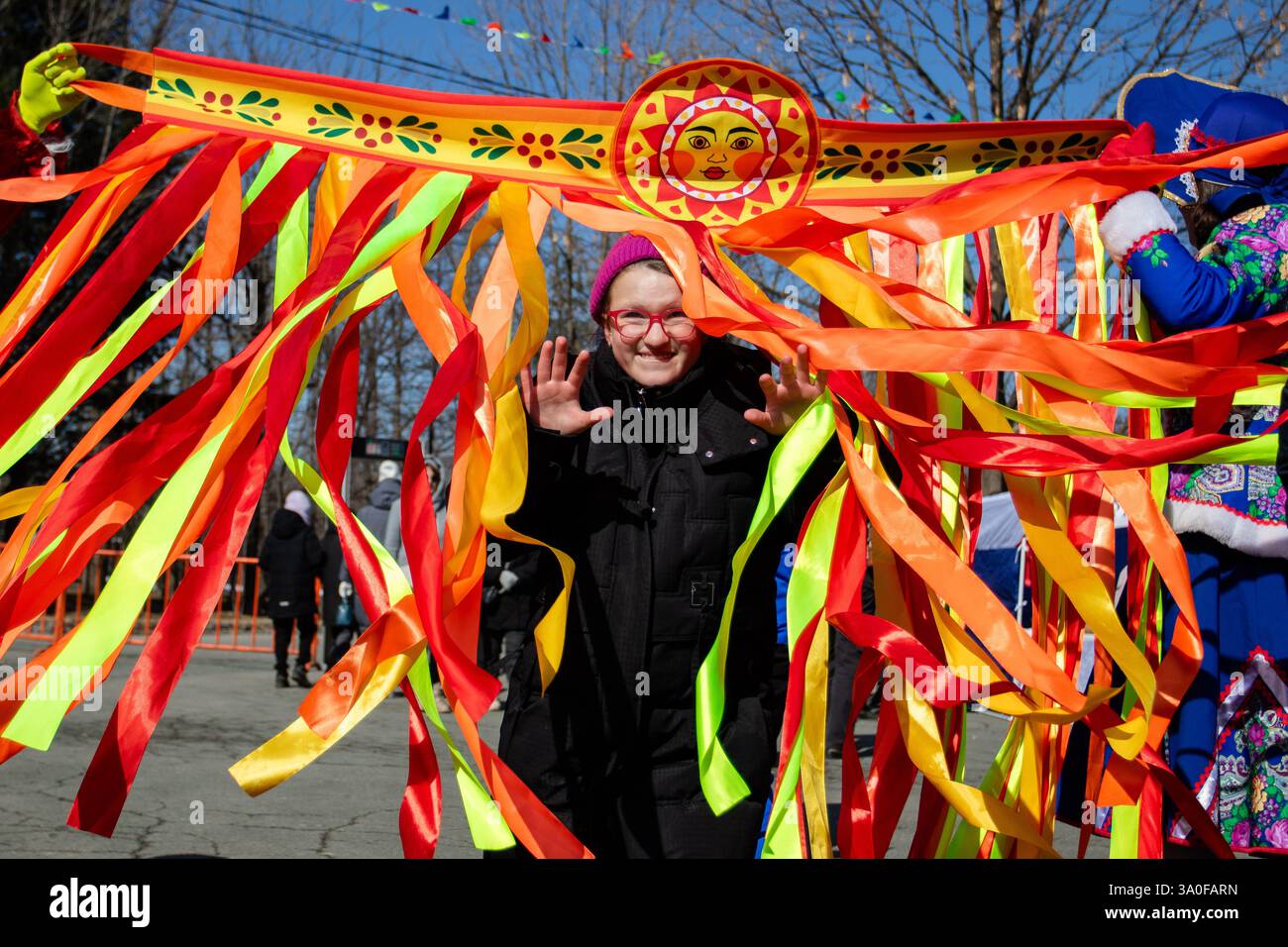Artem, Russland. März 2025. Ein Mädchen geht durch das symbolische Tor, das mit Bändern verziert ist. Die Russen feiern Maslenitsa traditionell. Die Bewohner der Stadt Artem in der Region Primorski betraten den Park der Kultur und Erholung, um den Winter zu verbringen. Maslenitsa in den Slawen ist ein Vorfahre, markiert innerhalb einer Woche vor einem großen Posten. Quelle: SOPA Images Limited/Alamy Live News Stockfoto