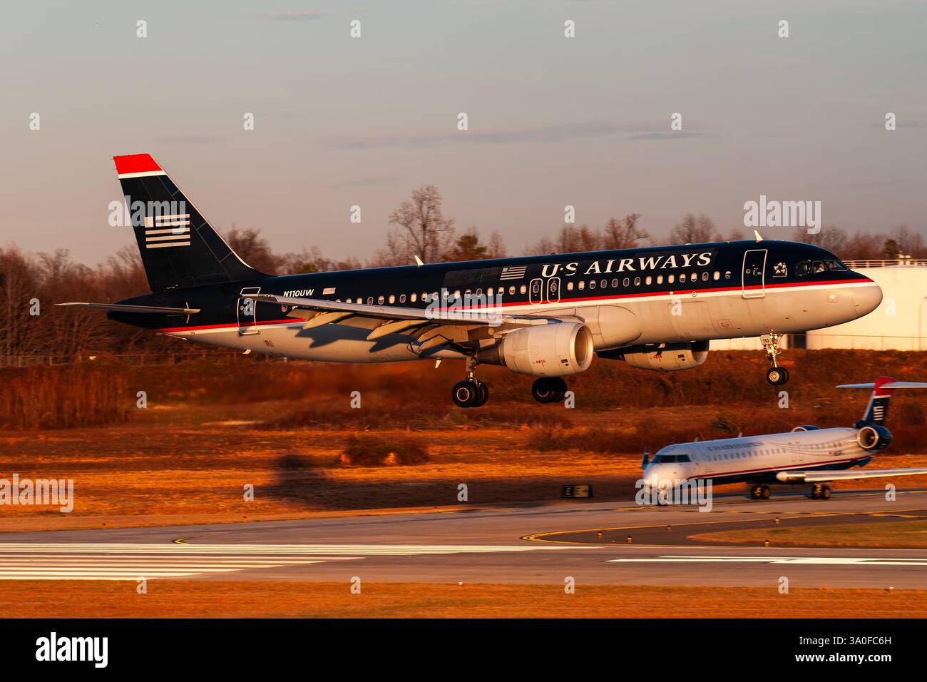Flughafen Charlotte Douglas Intl 12-24-2007 Charlotte, NC USA Airways Airbus A320 N110UW bei Sonnenuntergang Ankunft am Flughafen Charlotte Douglas International Airport Stockfoto