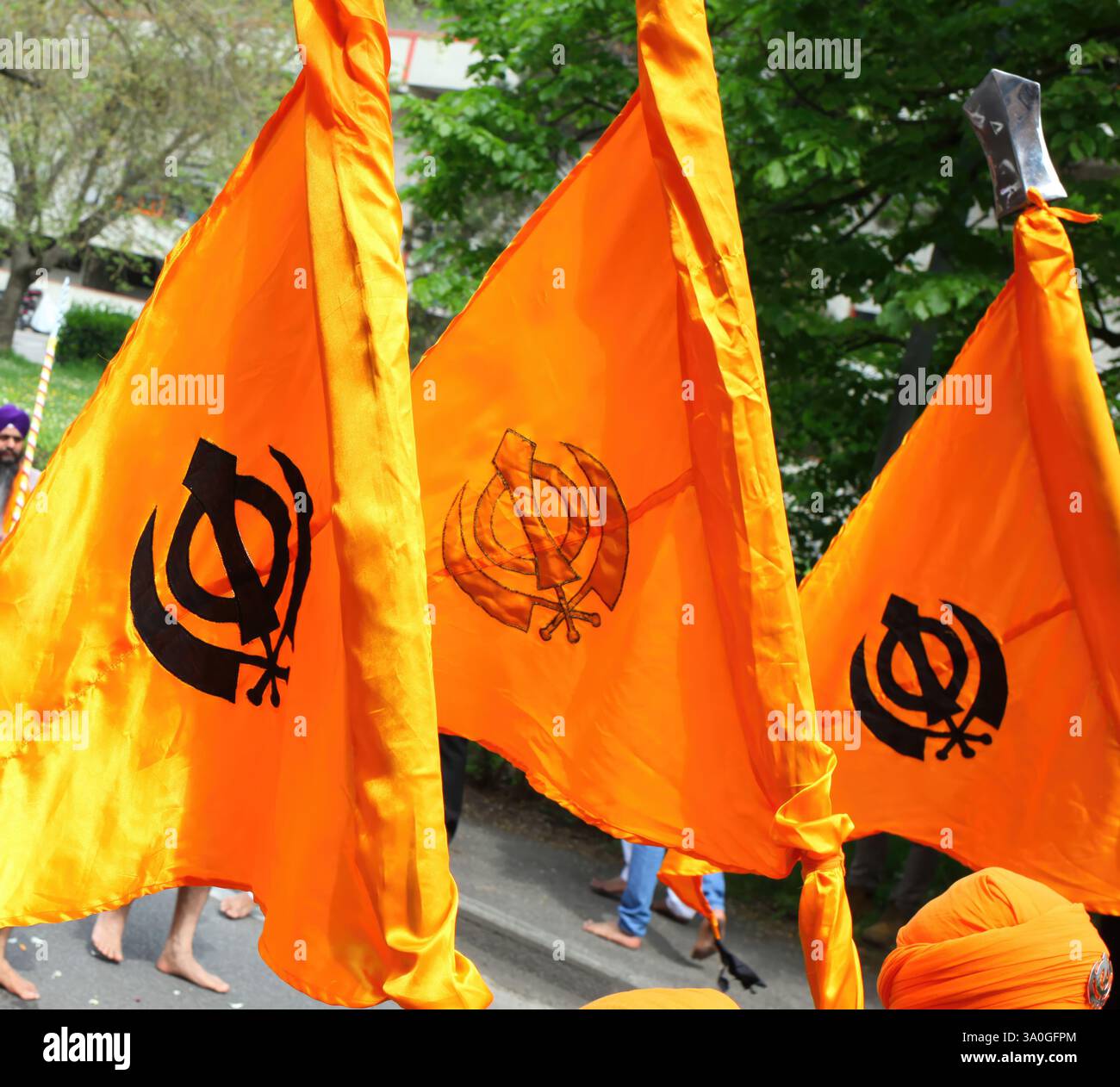 Safranfarbene Nishan Sahib-Flaggen mit dem Khanda-Symbol, das während einer Sikh-Feier im Wind winkt, repräsentiert Mut, spirituelle Souveränität, A Stockfoto
