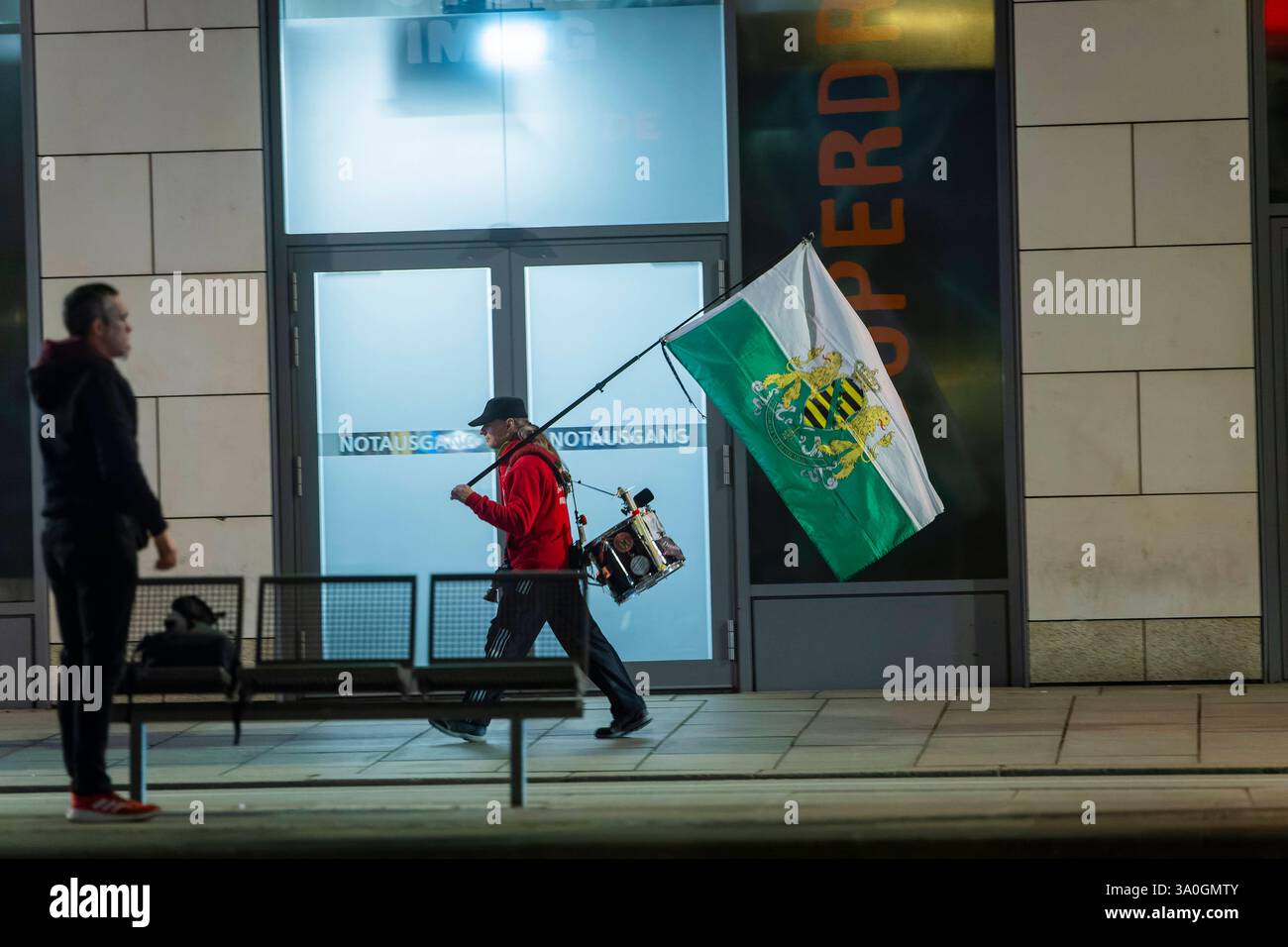 Demosntrant ein Passant schaut zu einem Anhänger der radikalen freien Sachsen, welcher mit Sachsenfahne und Trommel auf der Wilsdruffer Straße. Zur montäglichen Demonstartion geht. Dresden Sachsen Deutschland *** Demosntrant Ein Passant schaut auf einen Unterstützer der radikalen Freisachsen, der mit sächsischer Flagge und Trommel auf der Wilsdruffer Straße für die Montag-Demonstration Dresden Sachsen Deutschland läuft Stockfoto