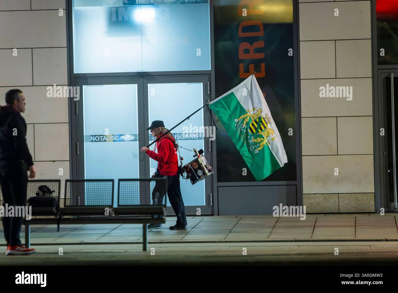 Demosntrant ein Passant schaut zu einem Anhänger der radikalen freien Sachsen, welcher mit Sachsenfahne und Trommel auf der Wilsdruffer Straße. Zur montäglichen Demonstartion geht. Dresden Sachsen Deutschland *** Demosntrant Ein Passant schaut auf einen Unterstützer der radikalen Freisachsen, der mit sächsischer Flagge und Trommel auf der Wilsdruffer Straße für die Montag-Demonstration Dresden Sachsen Deutschland läuft Stockfoto