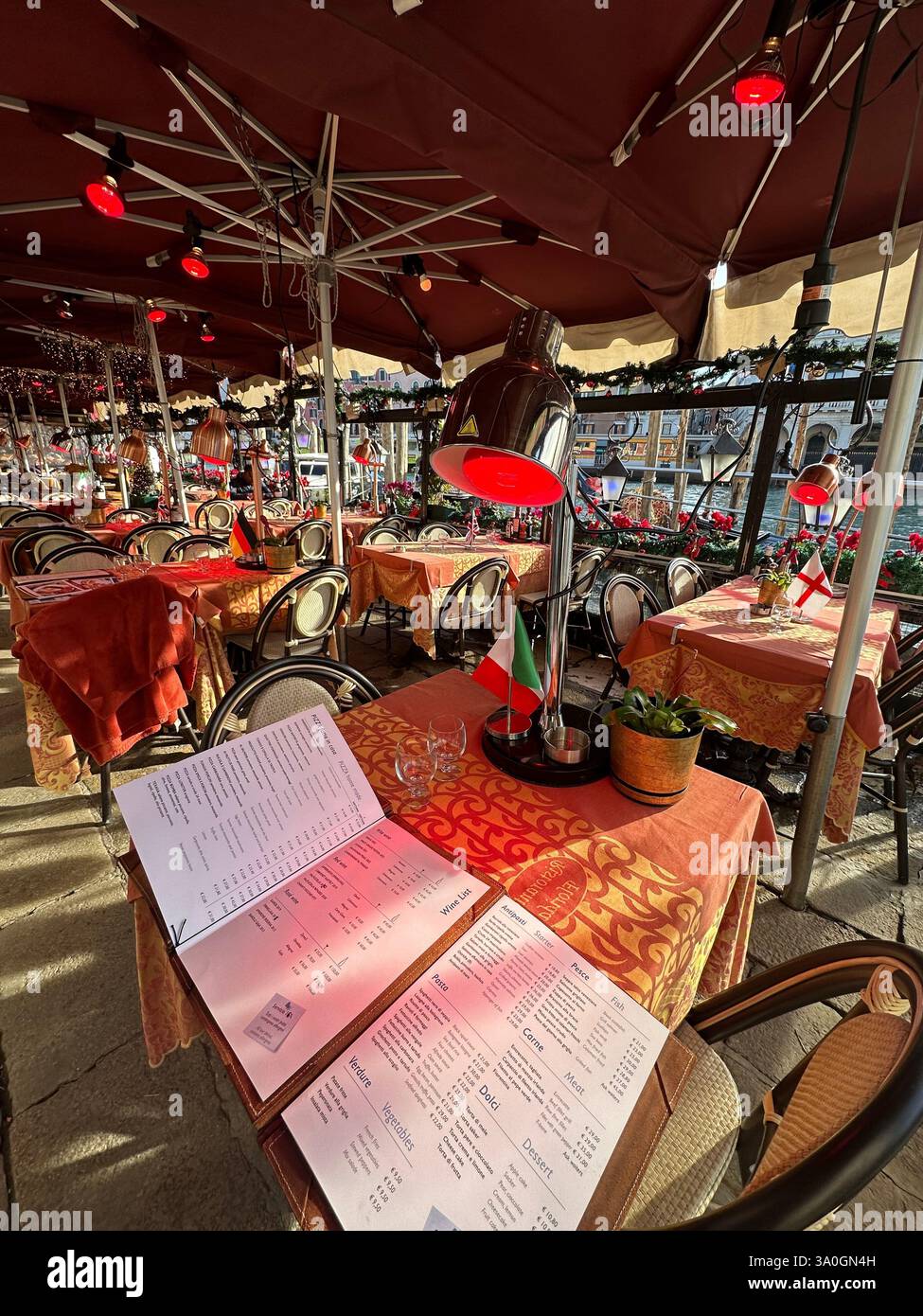 Restaurant Italian Food Grand Canal in Venedig bei Sonnenuntergang, mit historischen Gebäuden am Wasser und malerischem Blick auf die Rialtobrücke. - Smartphone-aufgenommenes Stockfoto