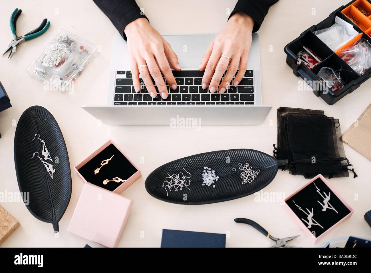 Top-Down-Ansicht eines Schmuckgeschäfts, der an einem Laptop arbeitet. Handmade Business, digitales Marketing, E-Commerce, Social Media-Strategie, Handwerk Stockfoto