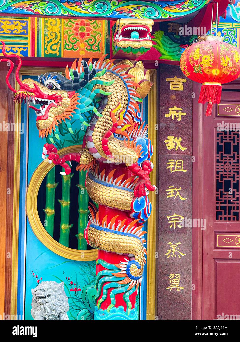 Lebendige Drachenskulptur auf einer chinesischen Tempelsäule Eine detaillierte und farbenfrohe Drachenskulptur, die um eine Säule in einem traditionellen chinesischen Tempel gewickelt ist. Stockfoto