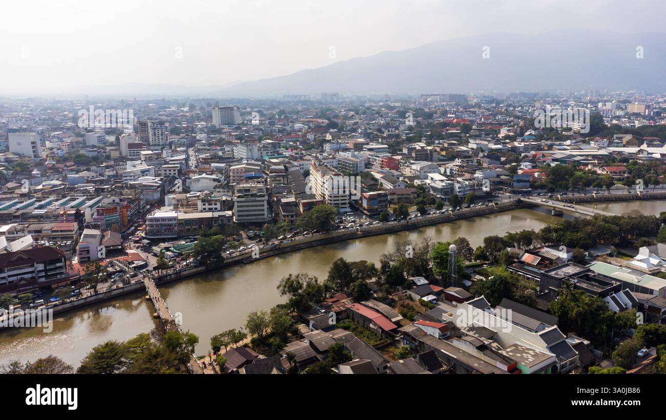 Verschmutzte Luftaufnahme der Stadt Chiang Mai mit dem Fluss Ping, der die Innenstadt und den Berg Doi Suthep im Hintergrund überquert, in schmutziger Luft von Verbrennungen Stockfoto