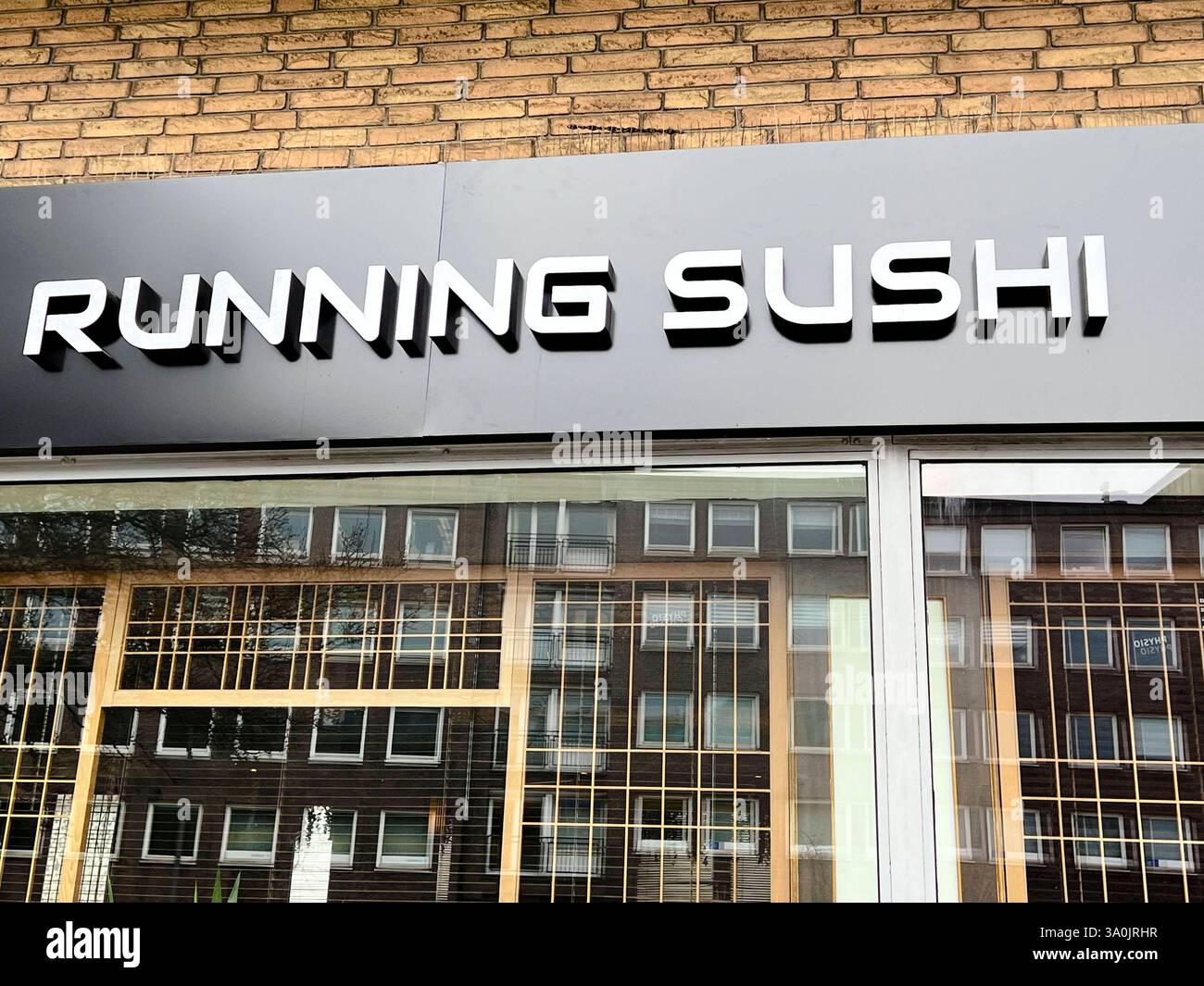 Running Sushi Logo Buchstaben an der Hauswand des Lokalin Hamburg Wandsbek - Kaiten Zushi ummlaufende Sushi werden japanische Restaurants für Sushi bezeichnet, bei denen die Speisen auf einem rundlaufenden Fließband angeboten werden haeufig auch als Running-Sushi bezeichnet. Hamburg Deutschland *** Running Sushi-Logo-Buchstaben an der Wand des Hamburger Restaurants Wandsbek Kaiten Zushi Running Sushi ist der Name japanischer Sushi-Restaurants, in denen das Essen auf einem Drehförderband serviert wird, oft auch als Running Sushi Hamburg Deutschland bezeichnet Stockfoto