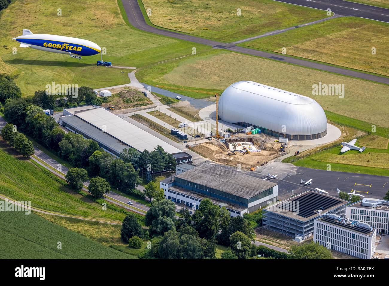 Luftaufnahme, Flughafen Essen/Mülheim, Baustelle neben Luftschiffshangar und Zeppelin Goodyear, Haarzopf, Essen, Ruhrgebiet, Nordrhein-Westph Stockfoto