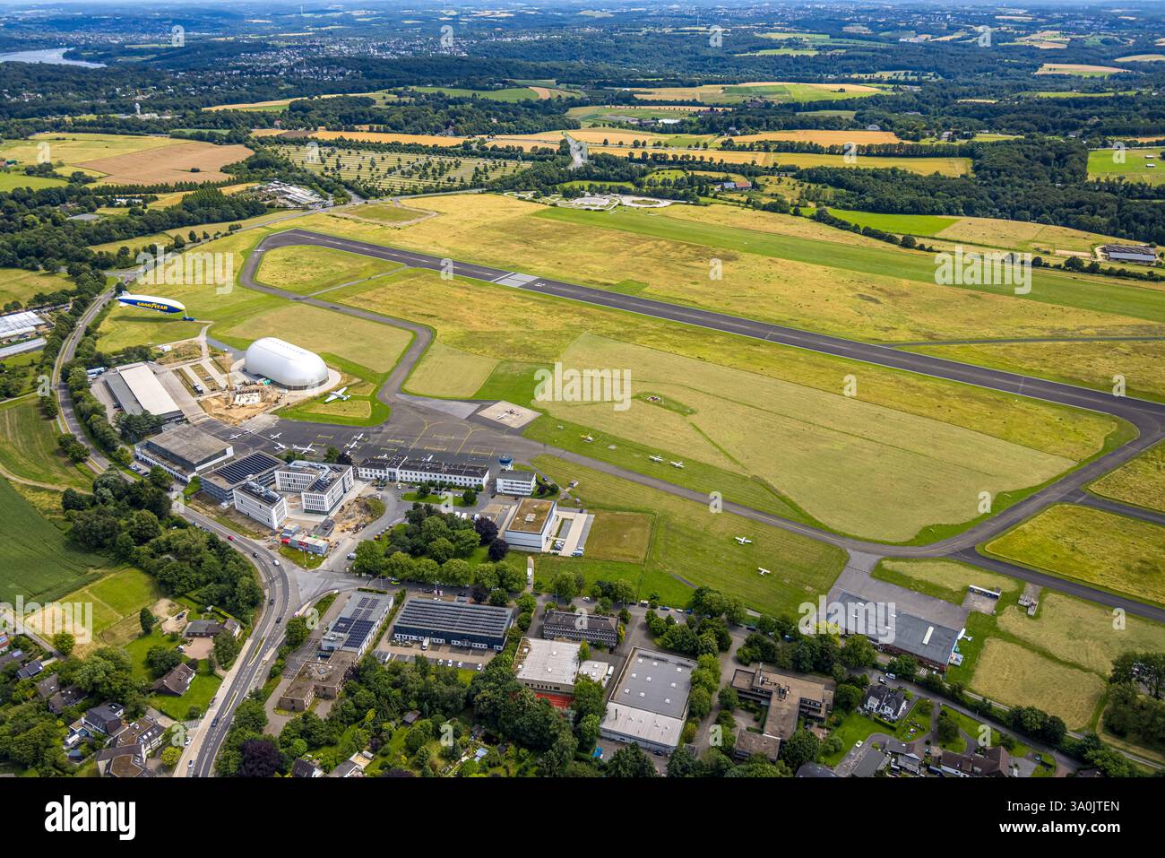 Luftaufnahme, Flughafen Essen/Mülheim, Baustelle neben Luftschiffshangar und Zeppelin Goodyear, Landebahn und Landebahn, geparkte Flugzeuge, Co Stockfoto