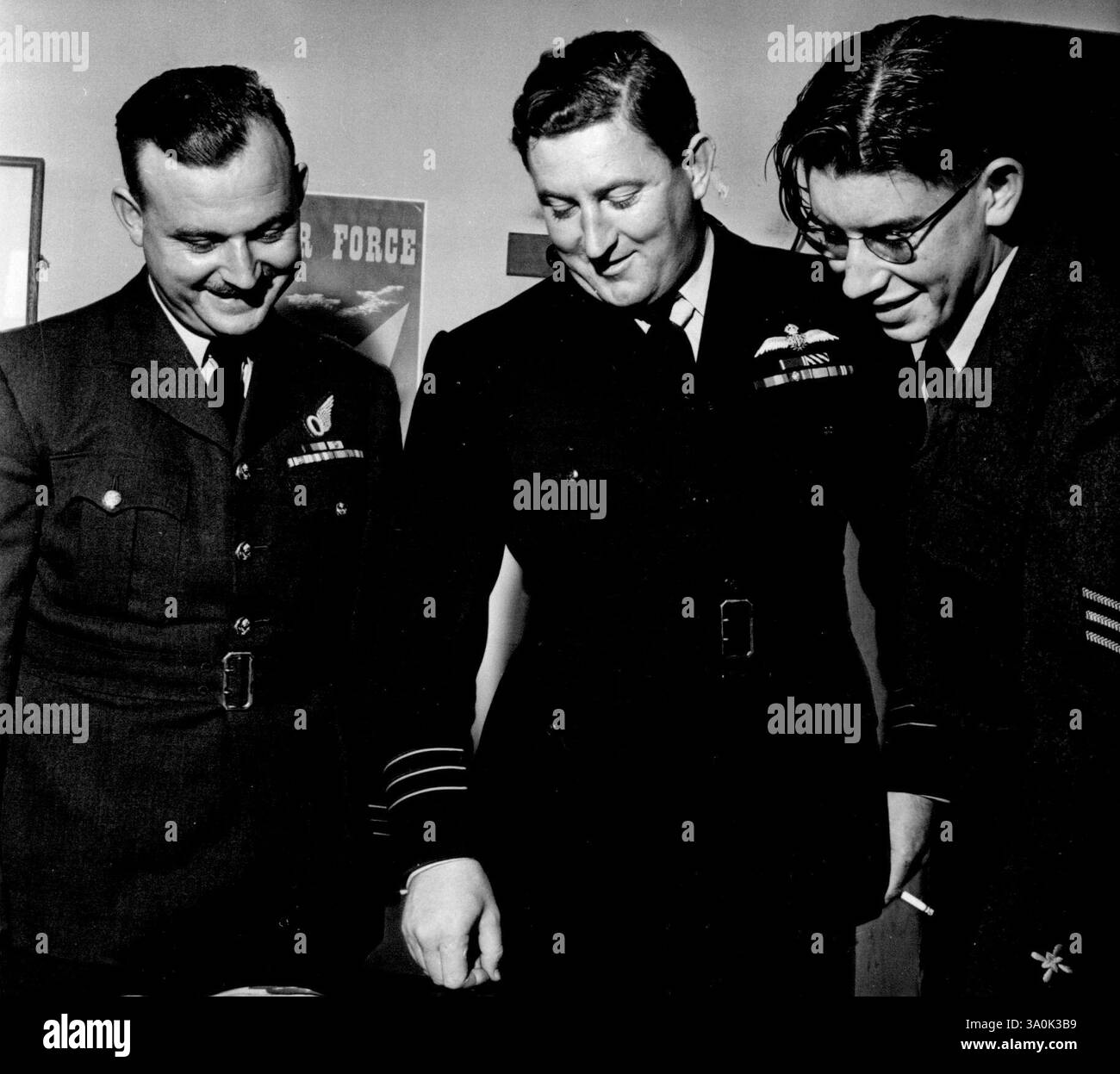 Der Erste Luftkadett Fliegt Über Den Nordpol. L bis R Sq/LDR. R. T. Billett, der Navigator, W./Commander. E. Russell-Bell, Kapitän und Pilot des Fluges, und David Cox, sehen Sie sich einige der Bilder an, die über dem Nordpol aufgenommen wurden. Flt. Sgt. Cadt David Cox ist der erste Air Codet, der den Nordpol überflog. Er flog mit einem Lincoln 4-Triebwerk-Bomber und wurde als Mitglied der Crew behandelt. Er wechselte sich in der Navigation unter dem Navigator Sq.LDR. R. T. Ballett ab. Juli 1950. Stockfoto