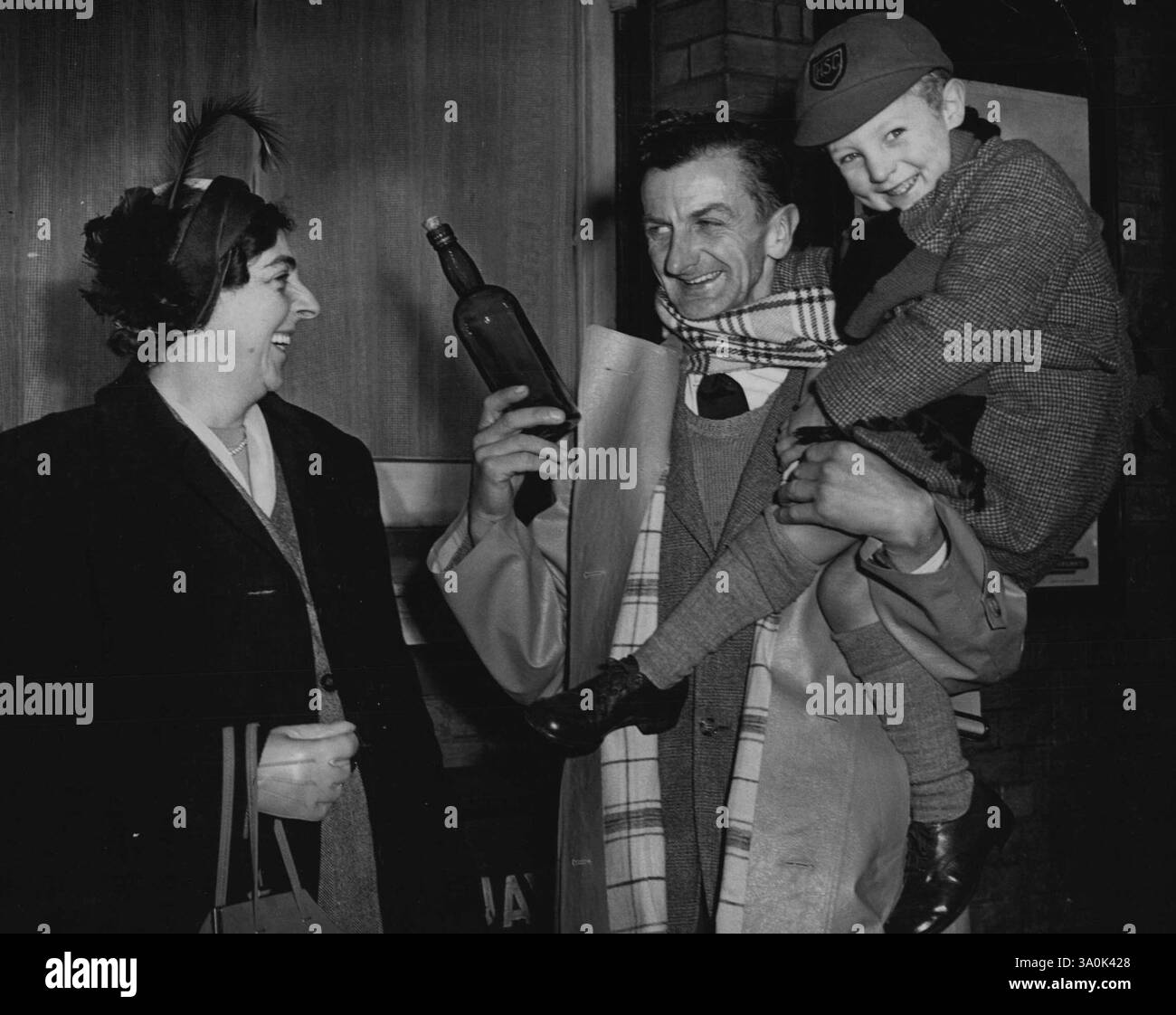 Dane nimmt eine Einladung an, die in einer Flasche gefunden wurde, die mit ihren drei Söhnen am Pier in Gorleston-on-Sea spielt. Im September warf Mrs. Helen Mills aus Church-Road, Gorleston, eine Flasche mit Korken ins Meer. In der Flasche befand sich die Nachricht: „Wer jemals diese Flasche mit der Nachricht findet, ist willkommen, einen Urlaub in unserem Haus zu verbringen“ - sie war mit der Unterschrift „Mrs. Helen Mills“ versehen. Wochen vergingen, und letzten Monat kam eine Nachricht aus Dänemark, geschrieben von Hans Oksen, einem Sohn eines dänischen Bauern, der das Angebot eines Urlaubs annahm. Dezember 1950. Stockfoto