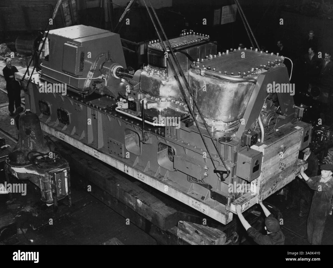 Heben der Gasturbine, des Generators und der Bettplatte aus dem Bogey bei der Ankunft in Newcastle. Das erste Handelsschiff der Welt, das von einer Gasturbine angetrieben wird, liegt jetzt im Norden Englands, wo die neue Triebwerkseinheit installiert wird. Der Tanker ist der "Auris", 12.000 Tonnen und gehört zu ***** Anlage. Die Gasturbine, gebaut von der ***** Thomson-Houston Company, wird mit Hilfe des 150 Tonnen schweren Titse, dem größten Schwimmkran der Tyne, installiert. Die "Auris" werden im Mund getestet. Oktober 1951. (Foto vom United Kingdom Information Service). Stockfoto