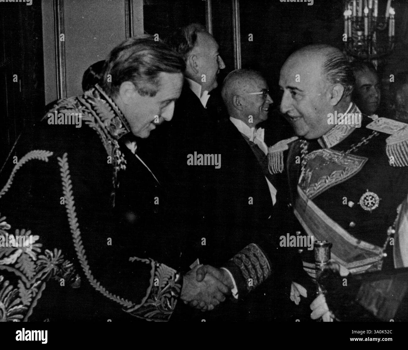 Franco wirft Eine Partei - der britische Botschafter Sir John Balfour wird vom General begrüßt. General Franco hat kürzlich anlässlich seines 16. Jahrestages seines Machterwerbs in Madrid einen schillernden Empfang gegeben. Führende ausländische Diplomaten, viele in voller Uniform und verschiedenen Dekorationen, gaben dem Empfang einen Hauch von Vorkriegsbrillanz. Oktober 1952. (Foto: Paul Popper). Stockfoto