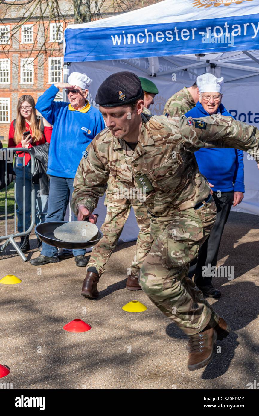 März 2025. Das jährliche Fastnacht-Pancake-Rennen fand heute in Winchester statt. Die vom Rotary Club in Zusammenarbeit mit der Winchester Cathedral organisierten Rennen, um Geld für wohltätige Zwecke zu sammeln, fanden an einem sonnigen Frühlingstag vor der Kathedrale statt. Stockfoto
