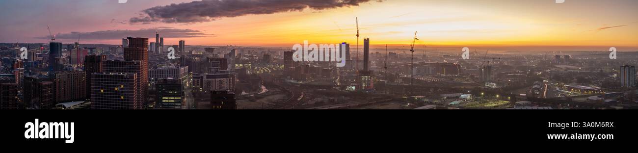 Panoramablick auf Leeds bei Sonnenaufgang, mit Stadterweiterung, hoch aufragenden Bauten und pulsierendem Stadtbild unter einem farbenfrohen Himmel. Stockfoto