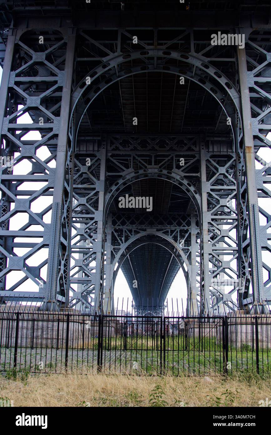 Mit Blick auf die Williamsburg Bridge, die historische und zeitgenössische Gebäude unterquert, fängt dieses Niedrigwinkelfoto das architektonische Erbe der Stadt ein. Stockfoto