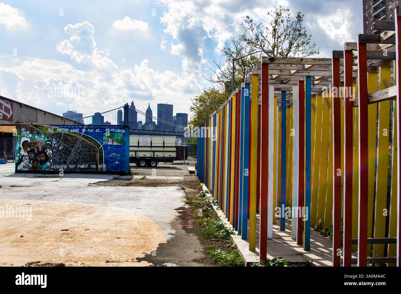 Farbenfrohe Kunstinstallation und Graffiti im East River Park, NYC vor dem modernen Bau Stockfoto