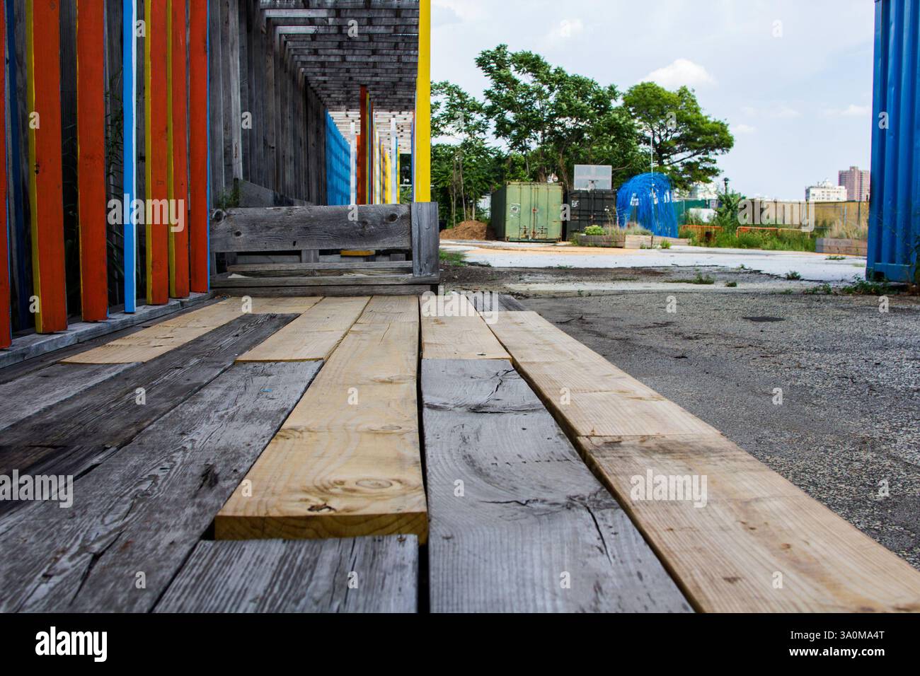 Farbenfrohe Kunstinstallation und Graffiti im East River Park, NYC vor dem modernen Bau Stockfoto