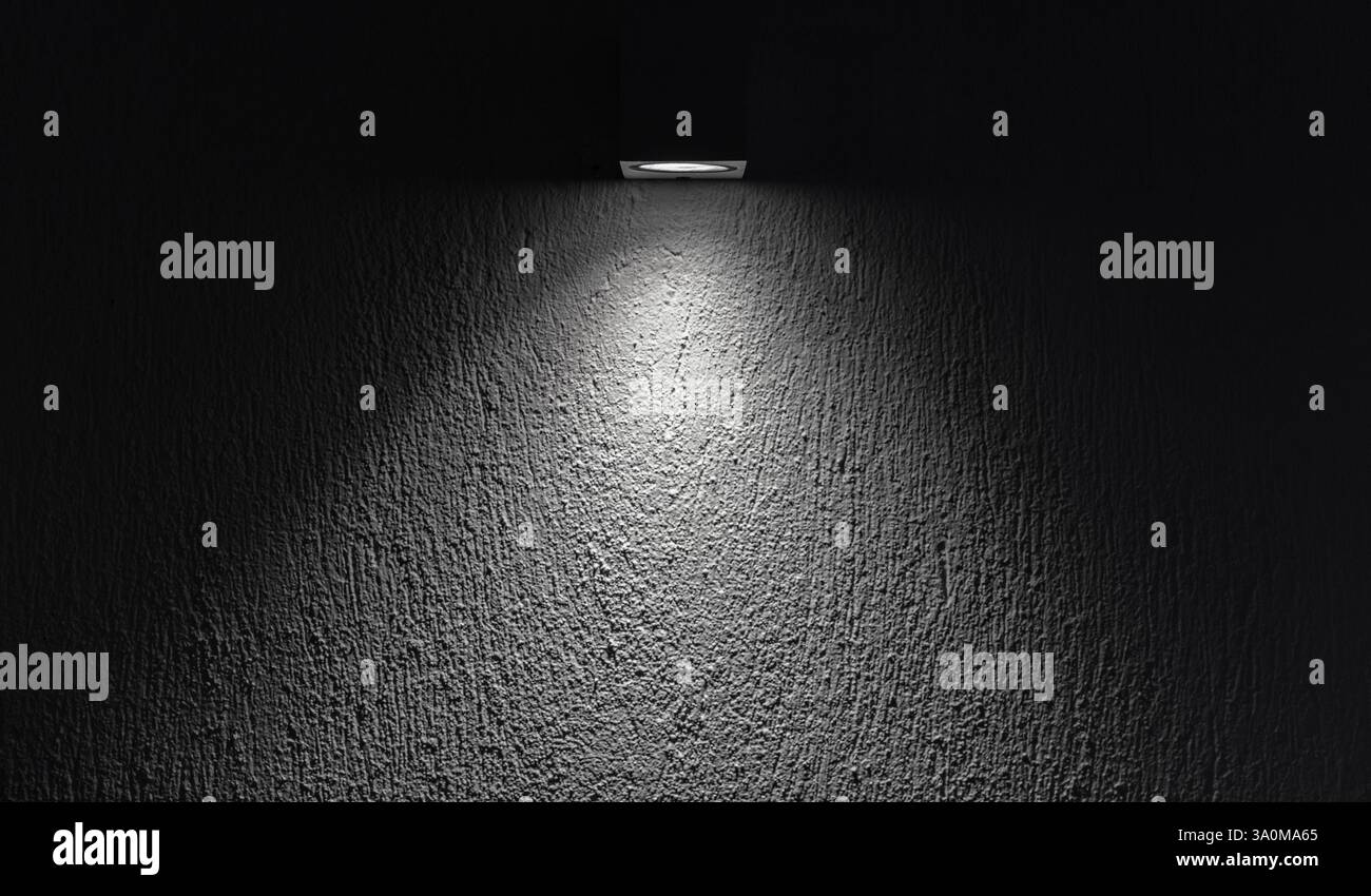 Weicher Spot-Lichtstrahl hebt eine strukturierte Wand hervor und schafft ein minimalistisches und charmantes Ambiente bei Dunkelheit. Hintergrundfotostruktur Stockfoto