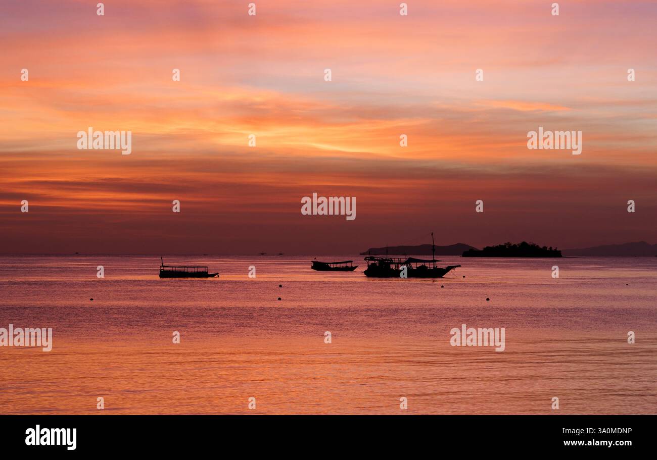 Blick auf den Sonnenaufgang auf das Boot vor der Insel Seraja Kecil, auch bekannt als Seraya, vor der Küste von Labuan Bajo, Indonesien. Die Insel ist die Heimat der S Stockfoto