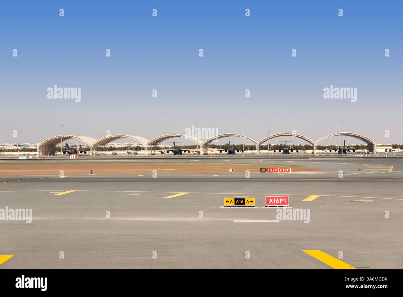 Start- und Landebahn des Flughafens Abu Dhabi mit Flugzeugen und schattigen Parkstrukturen Stockfoto Start- und Landebahn des Flughafens Abu Dhabi mit Flugzeugen und schattigen Parkstrukturen Stockfoto