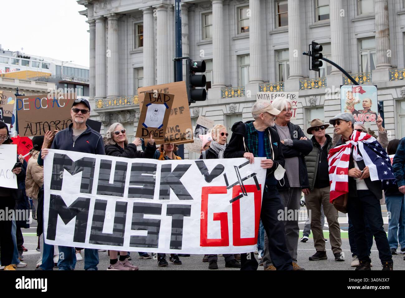 San Francisco, USA. März 2025. Demonstranten versammeln sich vor dem Rathaus von San Francisco, um gegen die Befehle von Präsident Trump und gegen die Aktionen von Elon Musk und seinem DOGENTEAM zu protestieren, einschließlich der Massenentlassungen von Bundesarbeitern. Zwei Männer halten ein großes Banner mit der Aufschrift: "Musk muss gehen." Quelle: Shelly Rivoli/Alamy Live News Stockfoto
