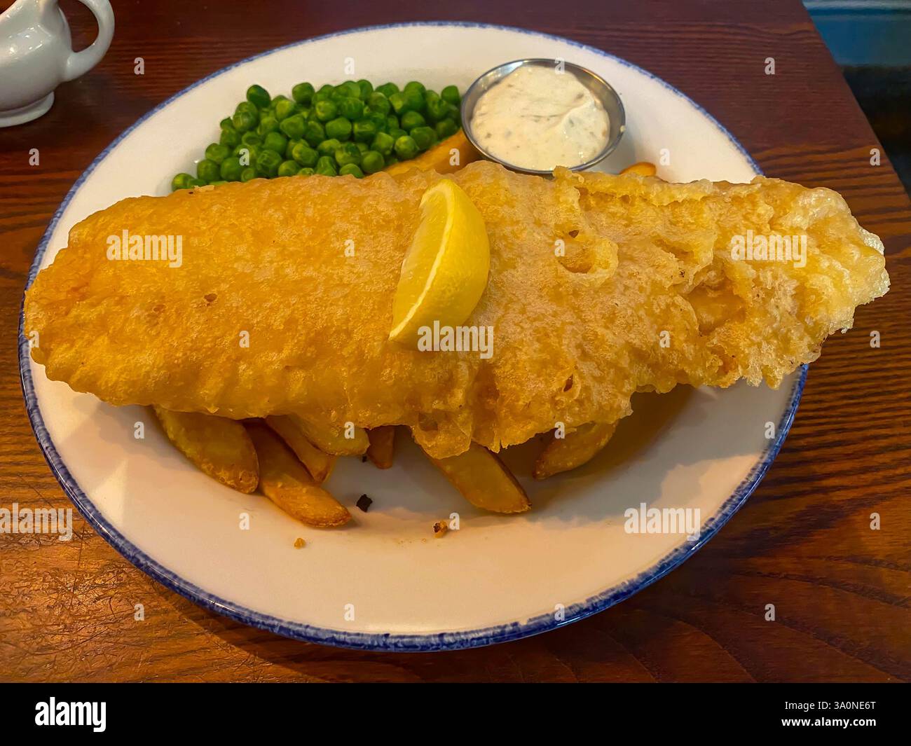 Traditioneller britischer Fisch und Chips, serviert in einem Pub zum Mittagessen - Smartphone-aufgenommenes Stockfoto