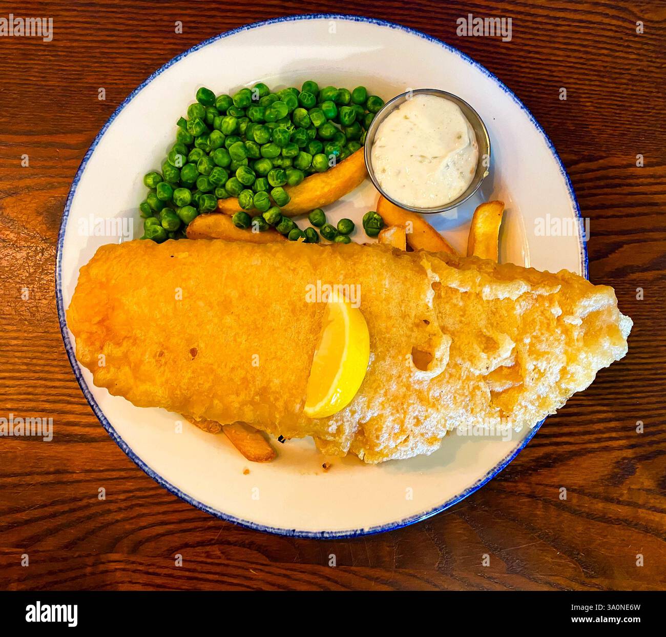 Traditioneller britischer Fisch und Chips, serviert in einem Pub zum Mittagessen - Smartphone-aufgenommenes Stockfoto