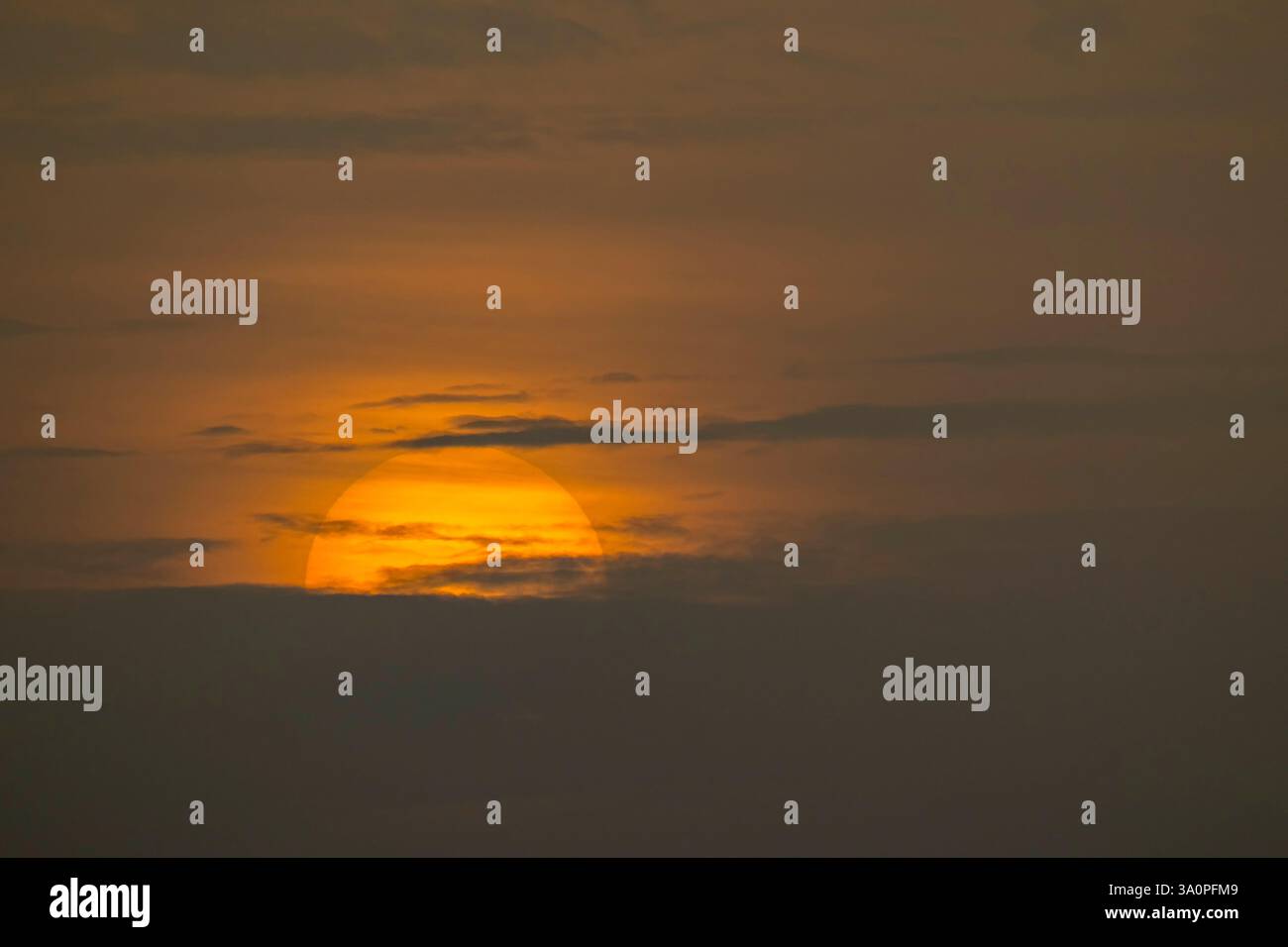 Wunderschöne große Sonne untergeht mitten in der Wolke, isolierte riesige Sonne in der Dämmerung, magische Momente am Himmel Stockfoto